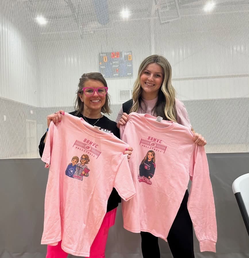 Mia Long and Emily Hamilton holding BAMVC shirts in a volleyball gym
