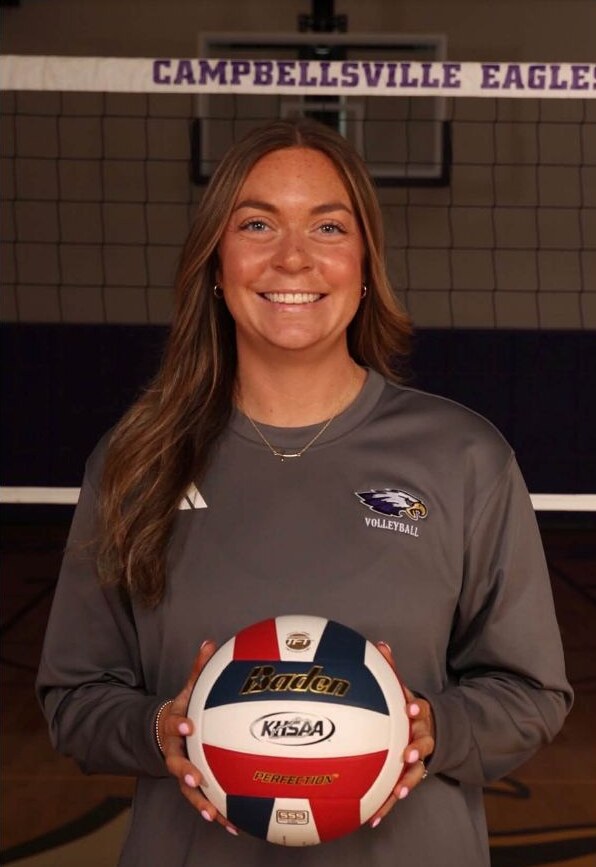 Tess Harley holding a volleyball in a gym